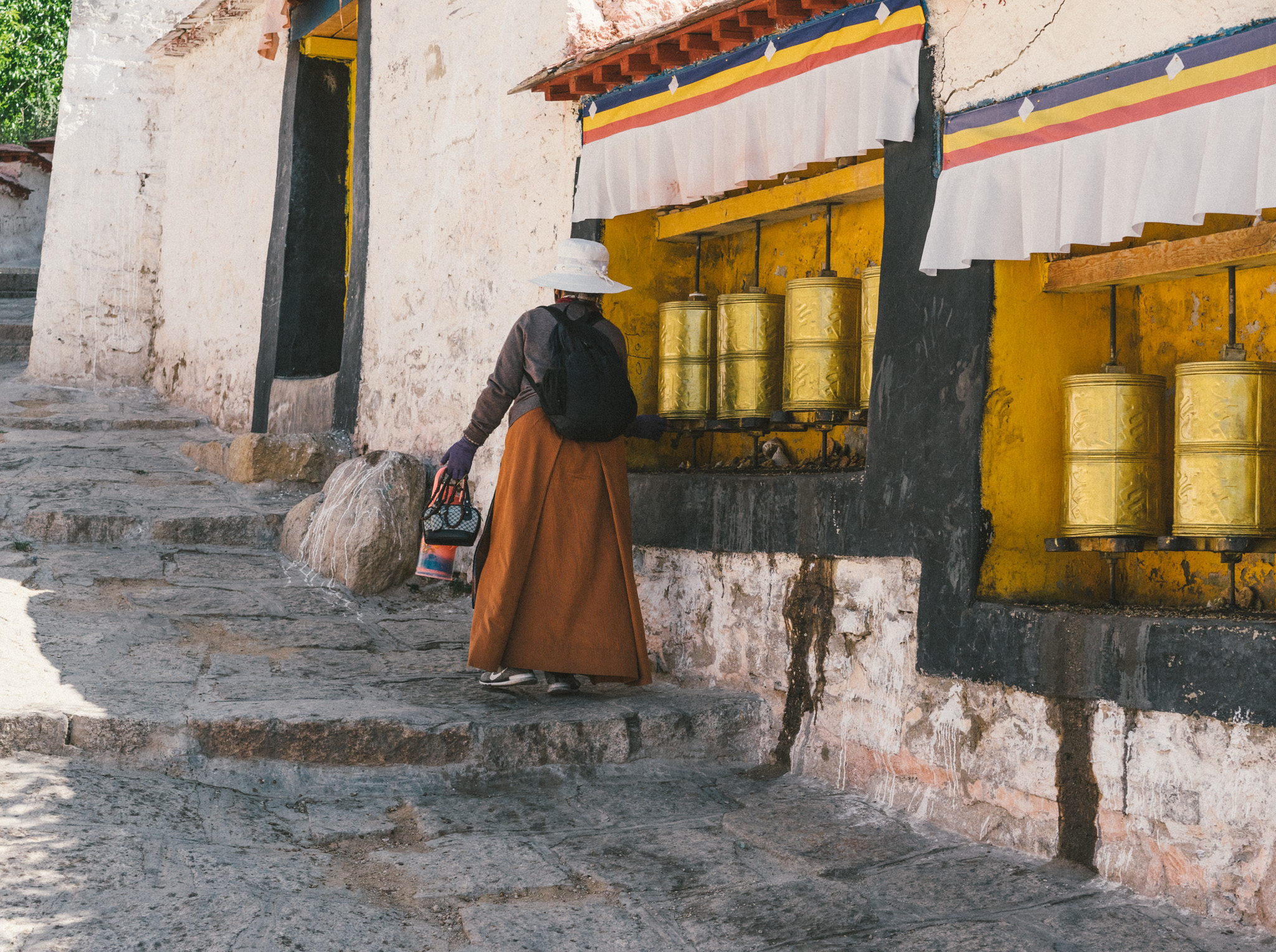 Tibetan woman spinning prayer wheels in the Sera Monastery