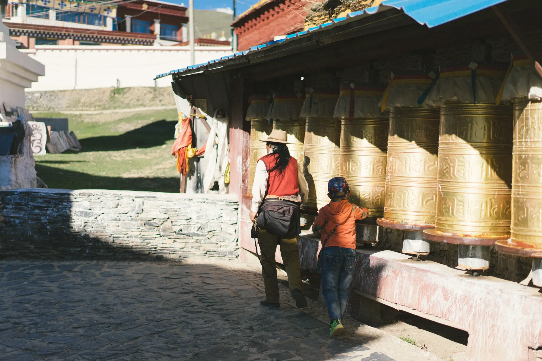 father and son spinning prayer wheels in Litang