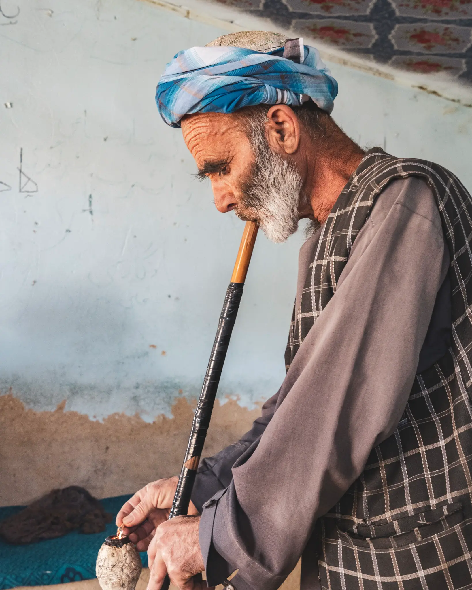 Man in Old Balkh smoking hash with his bong